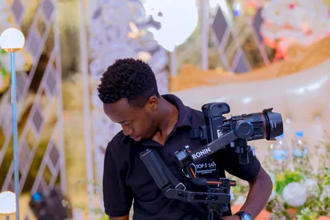 Un vidéaste équipé d’un stabilisateur filme dans un décor floral.
